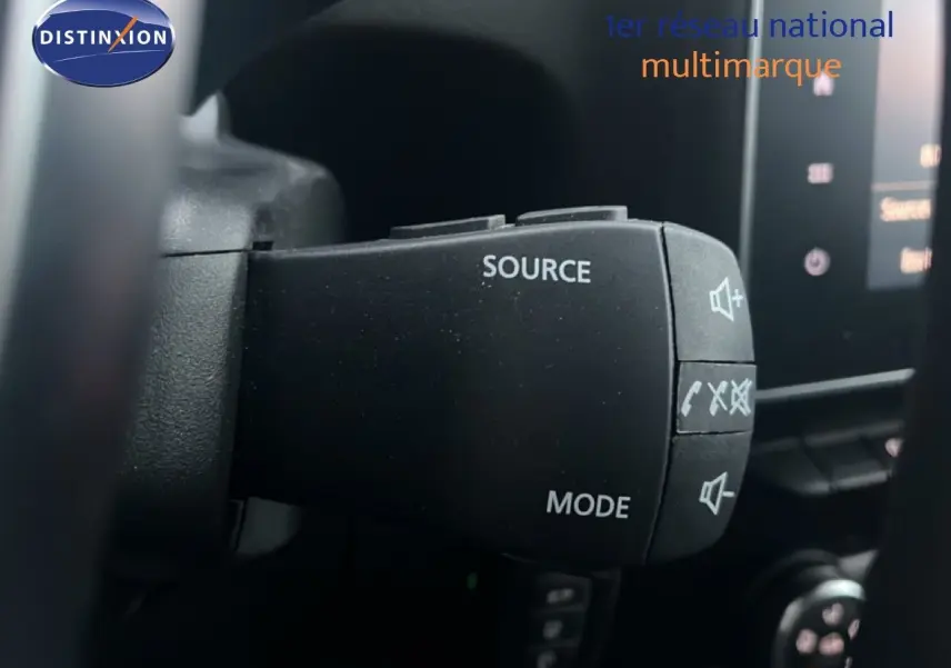 Gros plan sur la commande au volant du Renault Express Van blanc glacier, avec boutons source et mode visibles.