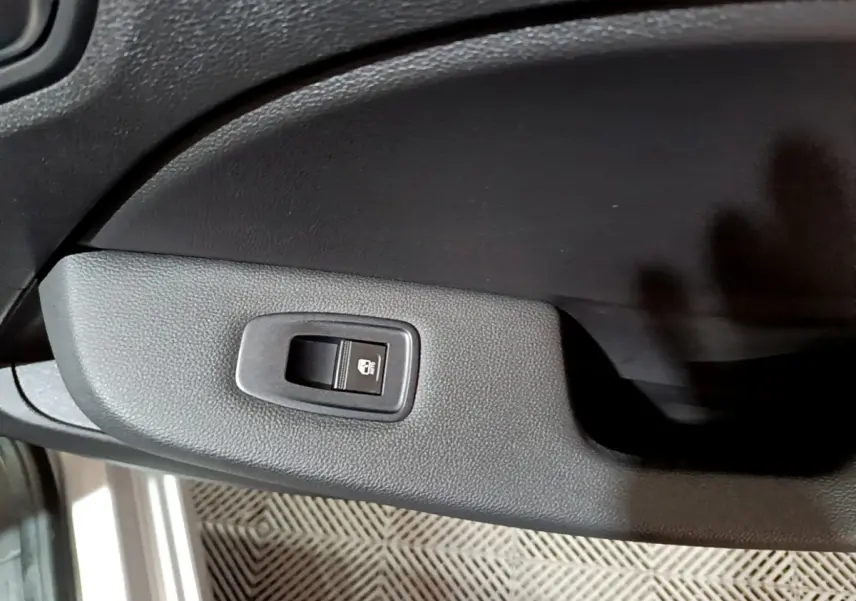 Gros plan sur le bouton de verrouillage des portes côté conducteur de la Renault Clio Equilibre TCe 90 gris clair 2023.