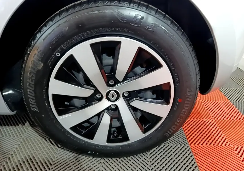 Gros plan sur la roue avant droite de la Renault Clio gris clair 2023 avec jante alliage bicolore et pneu Bridgestone.