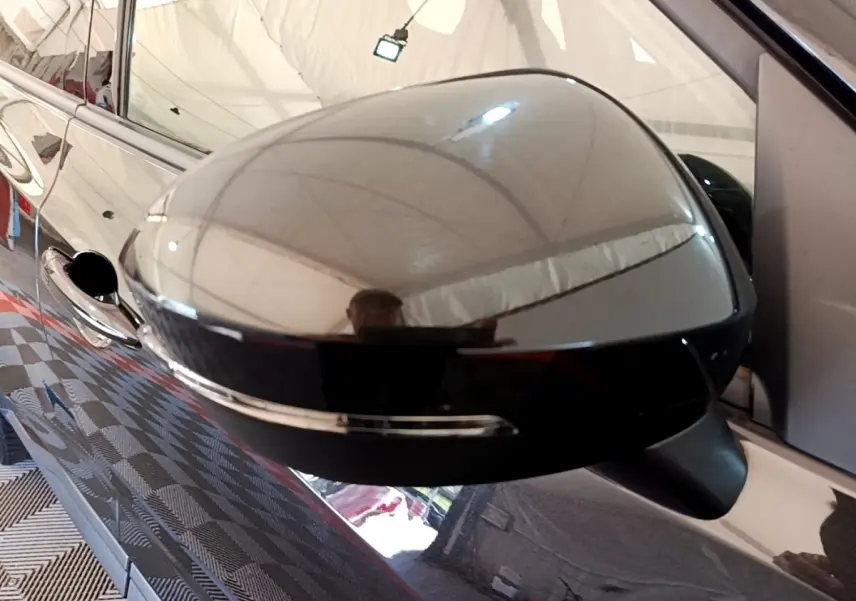 Rétroviseur extérieur noir brillant côté gauche d’un Nissan Juke 2022 avec clignotant intégré, vue rapprochée.