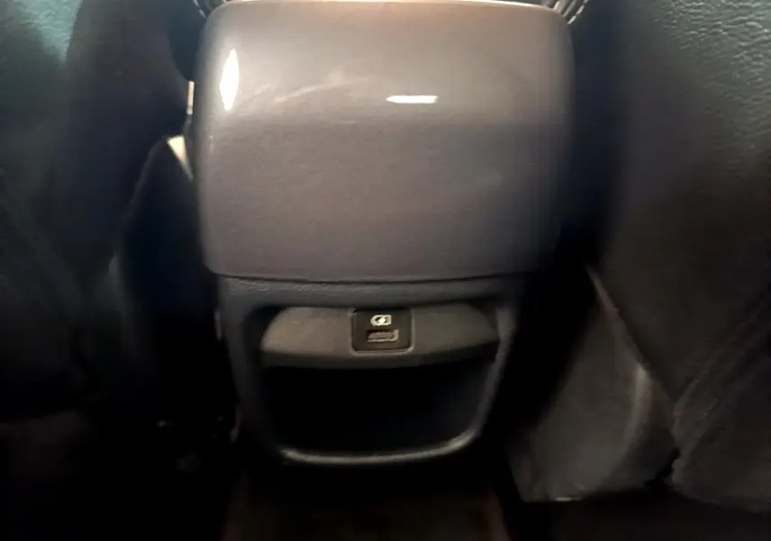 Vue rapprochée de la console arrière noire du Nissan Juke 2022 avec prise USB visible entre les sièges avant.