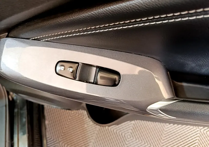 Gros plan sur la commande de verrouillage des portes sur la portière côté conducteur d’un Nissan Juke noir 2022.