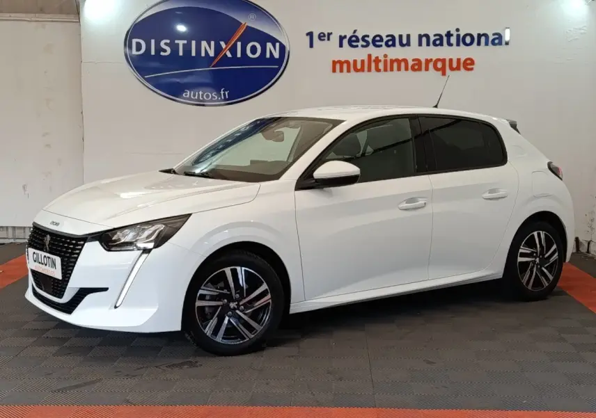 Peugeot 208 blanc vue de profil côté gauche, avec jantes alliage et feux avant LED visibles en intérieur showroom.
