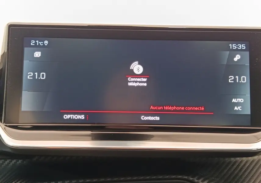 Écran tactile central affichant la connexion Bluetooth dans l’habitacle d’une Peugeot 208 blanche, vue de face.