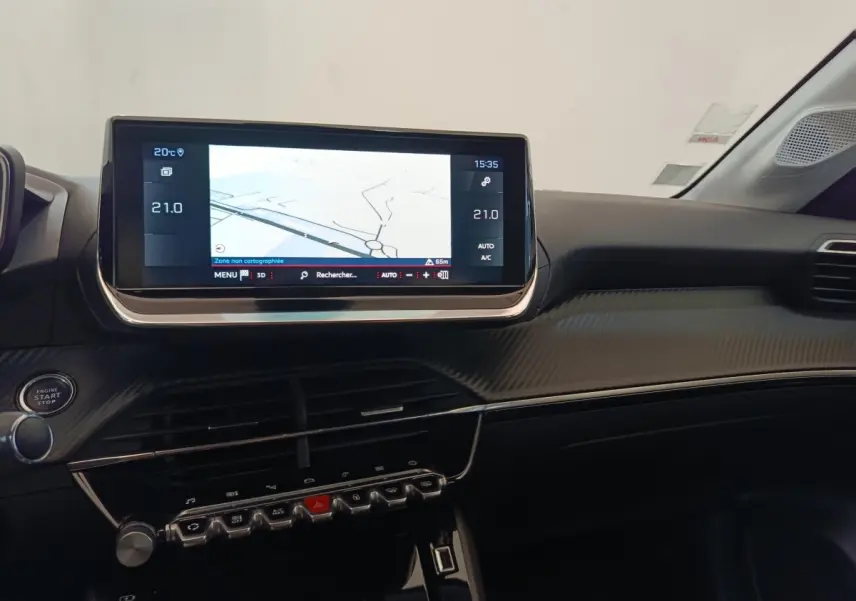 Vue intérieure du tableau de bord de la Peugeot 208 blanche, avec écran tactile de navigation 10 pouces et commandes intégrées.