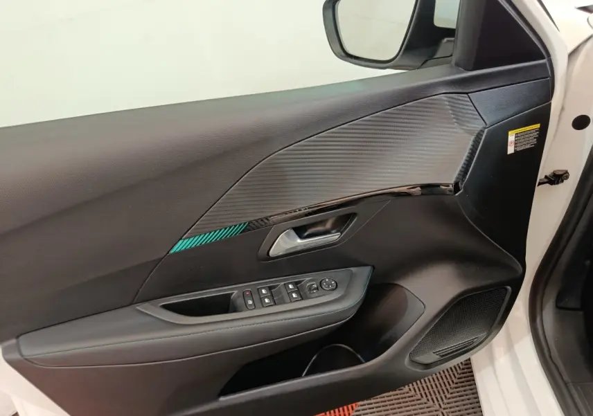 Intérieur de la porte avant gauche blanche d'une Peugeot 208 2021, avec insert décoratif et commandes électriques.