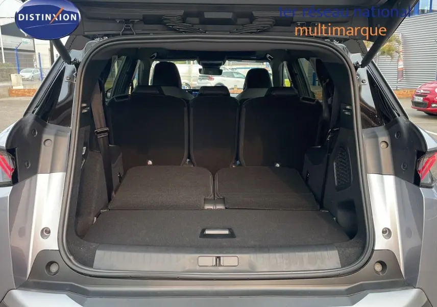 Coffre ouvert en vue arrière d'un Peugeot 5008 gris Artense métal avec toit noir, sièges arrière partiellement rabattus.