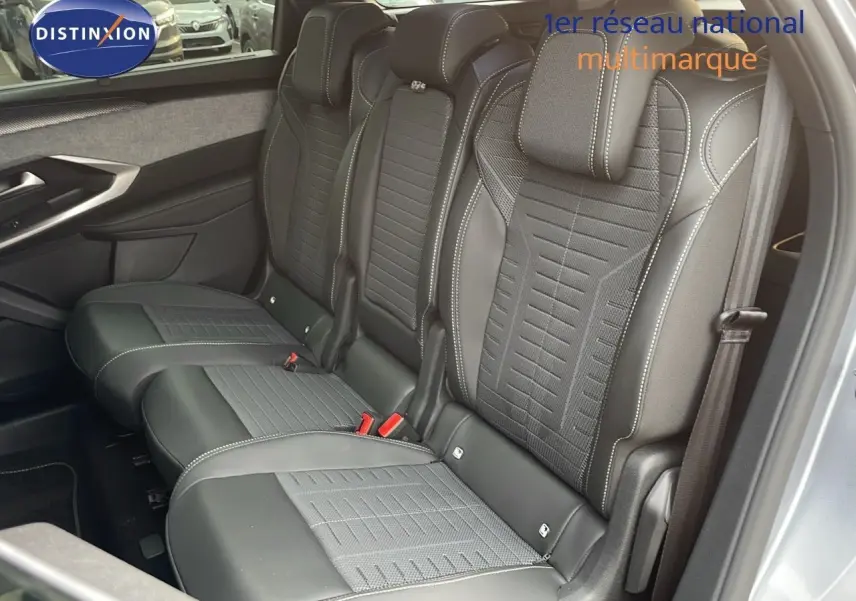 Vue intérieure côté droit des sièges arrière en cuir noir et tissu gris du Peugeot 5008 Hybrid 2025 avec surpiqûres contrastées.