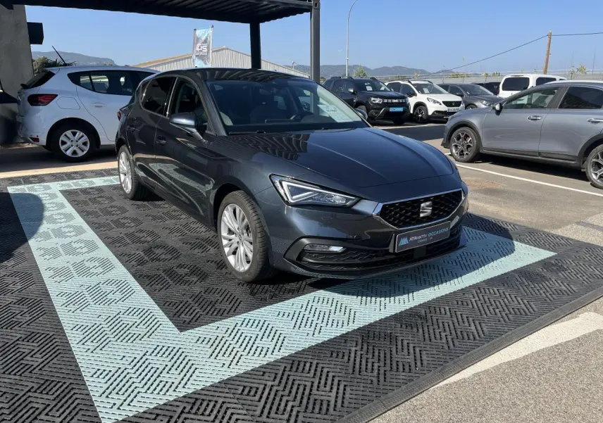SEAT Leon IV gris Magnetic Metal vue 3/4 avant droit, avec jantes alliage 17 pouces et phares LED allumés.
