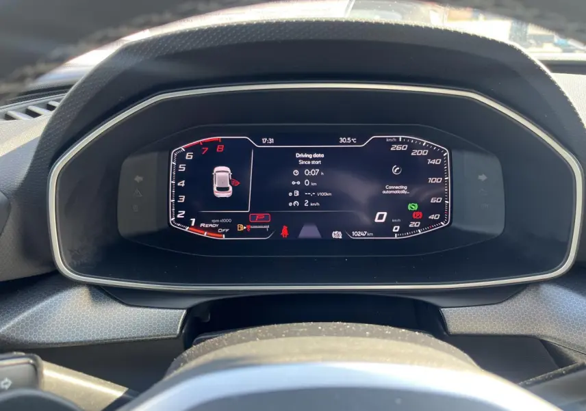 Vue rapprochée du tableau de bord numérique de la SEAT LEON IV gris Magnetic, affichant les données de conduite et la vitesse.