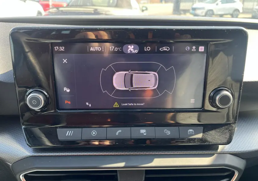 Écran tactile central du tableau de bord du SEAT Leon IV 2023 affichant l'aide au stationnement en vue aérienne.