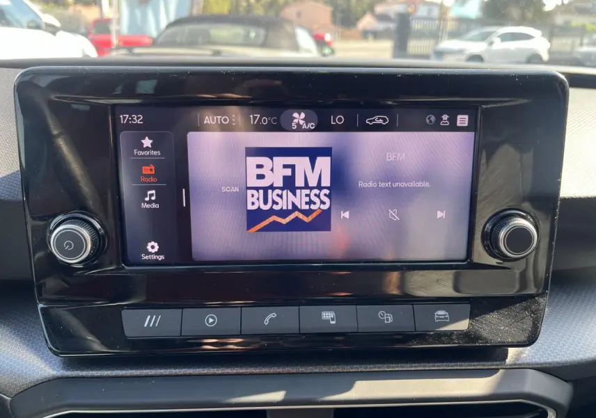 Écran central tactile du tableau de bord du SEAT LEON IV gris Magnetic, affichant la radio BFM Business.
