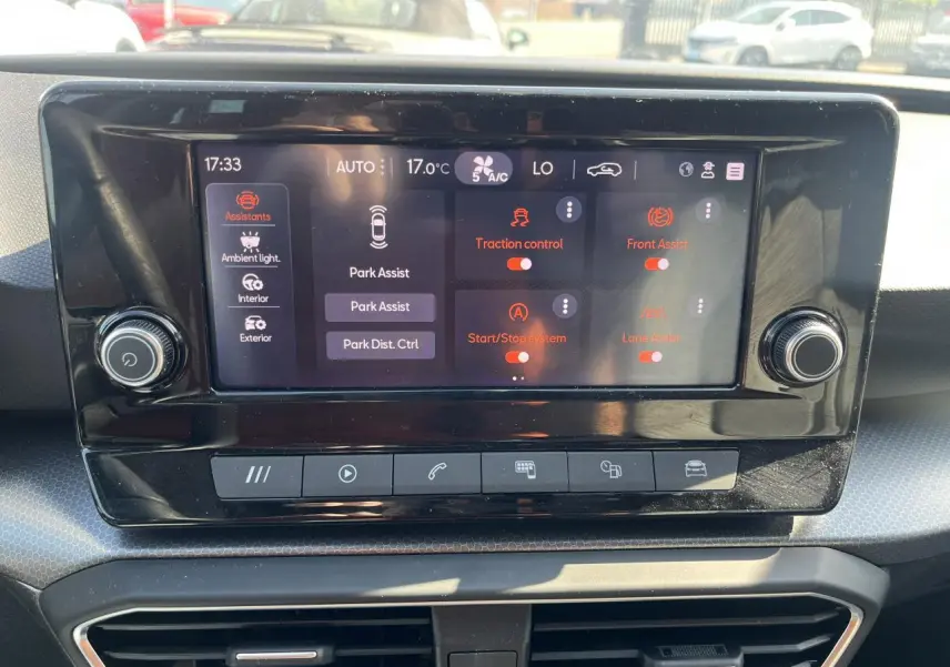 Écran tactile central du tableau de bord du SEAT Leon IV gris, affichant les options d'assistance à la conduite.