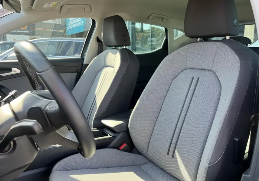 Vue intérieure sur les sièges avant gris clair et volant cuir multifonction du SEAT LEON IV 1.5 ETSI 150 SPECIALE EDITION 2023.
