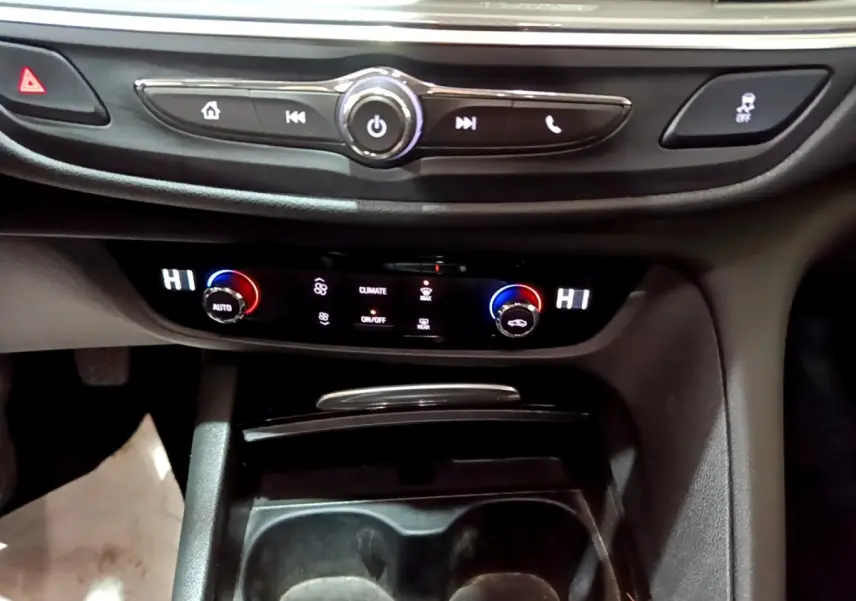 Gros plan sur la console centrale noire de l’Opel Insignia 2019, avec commandes climatisation digitale et boutons multifonctions.