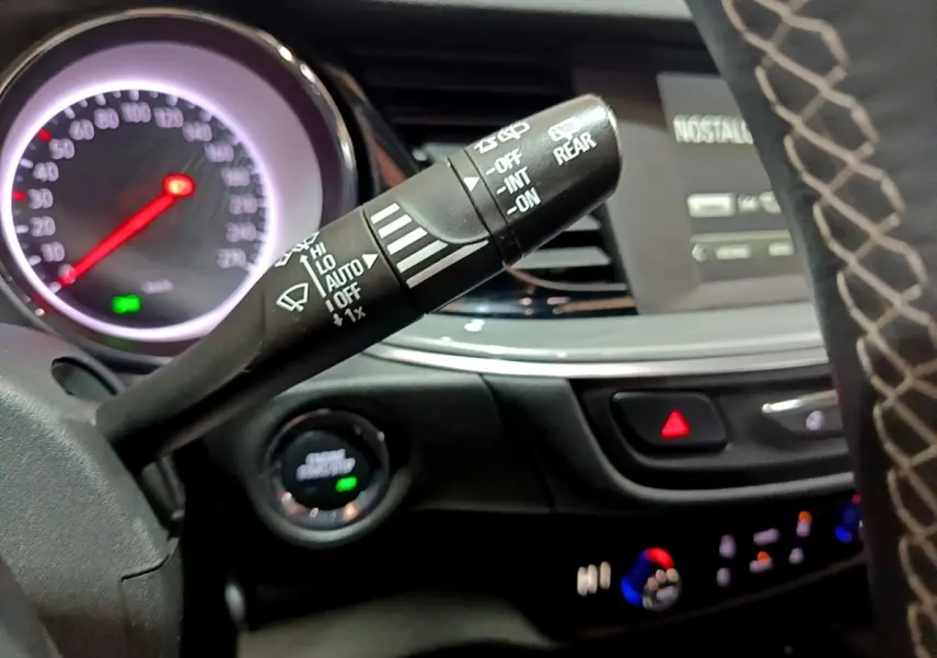 Gros plan sur la commande d’essuie-glace à gauche du volant dans l’habitacle d’une Opel Insignia rouge de 2019.