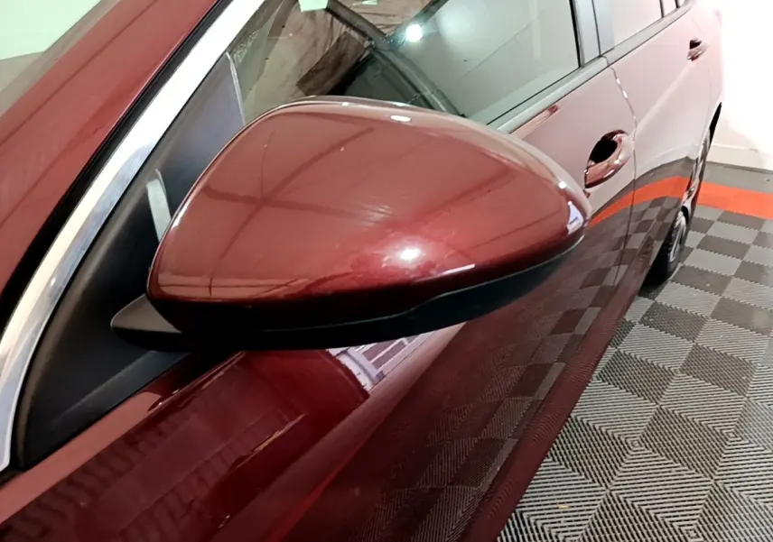 Rétroviseur côté gauche d’une Opel Insignia rouge 2019, vue rapprochée sur la portière et la poignée.