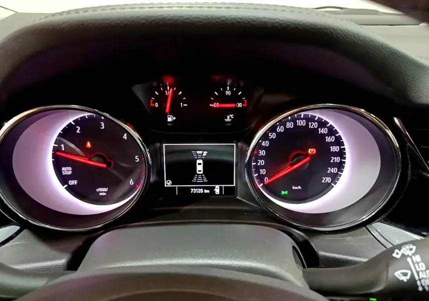 Vue rapprochée du tableau de bord de l’Opel Insignia 2019, affichage digital et compteurs analogiques éclairés.