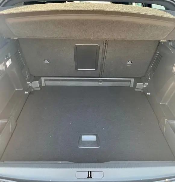 Coffre ouvert d'un Peugeot 3008 noir 2018, vue de l'arrière montrant un espace de chargement propre et bien agencé.