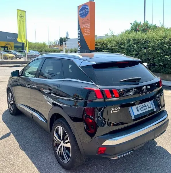 Vue 3/4 arrière droite d'un Peugeot 3008 noir 2018 GT Line avec feux arrière à griffes distinctifs et toit argenté.
