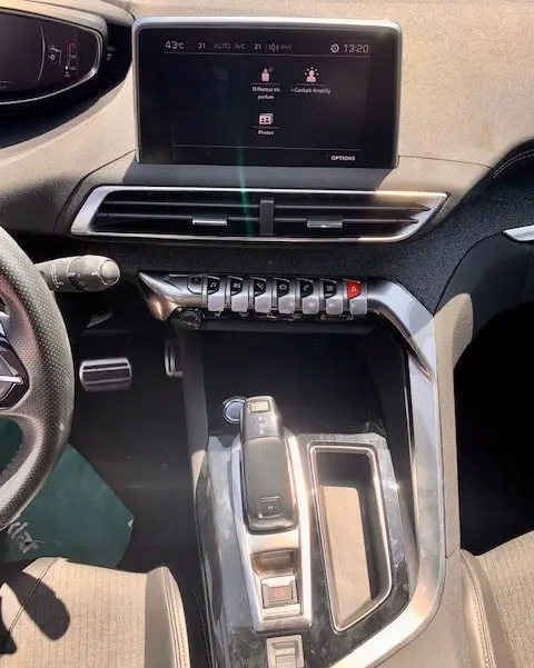 Vue intérieure de la console centrale et tableau de bord du Peugeot 3008 noir, avec écran tactile et commandes piano.