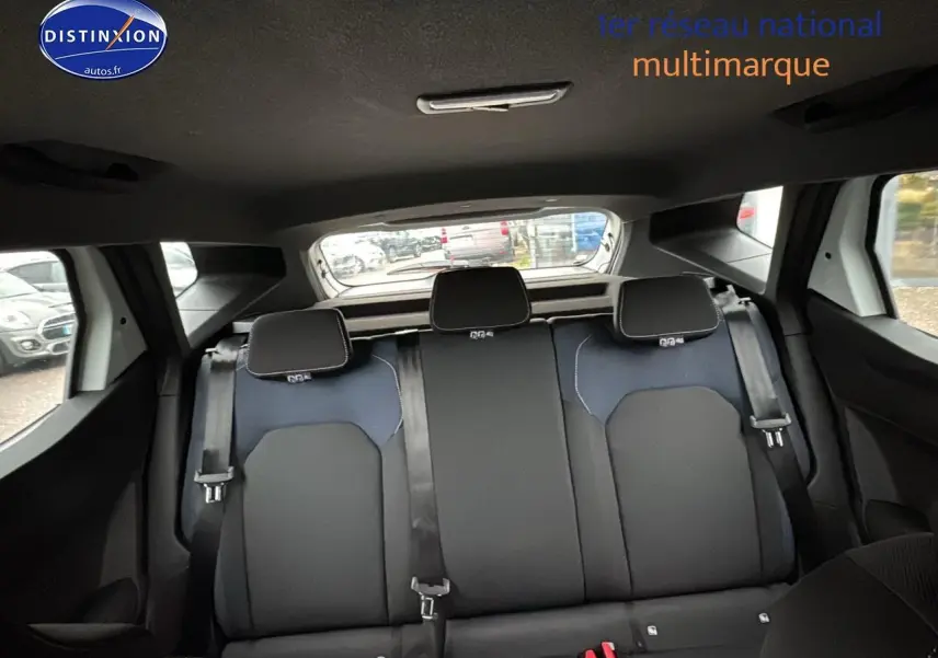 Vue arrière intérieure du Dacia Duster 2025 blanc arctic, montrant la banquette 3 places avec appuie-têtes et ceintures.