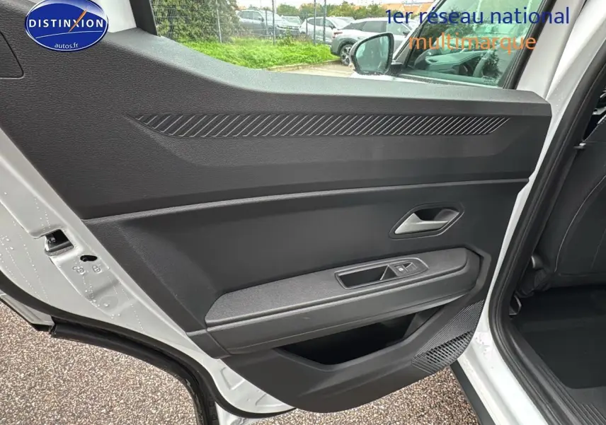 Vue intérieure de la porte arrière gauche blanche arctic du Dacia Duster 2025 avec commandes de vitre et rangement intégré.
