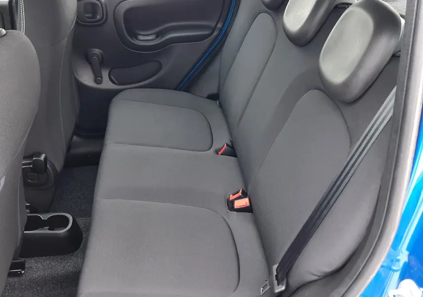 Vue intérieure côté droit des sièges arrière noirs en tissu de la Fiat Panda bleu Italia 2025 à cinq portes.
