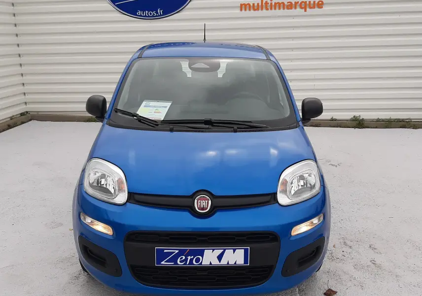 Vue frontale d'une Fiat Panda 2025 bleu Italia avec phares allumés et logo Fiat visible sur la calandre.
