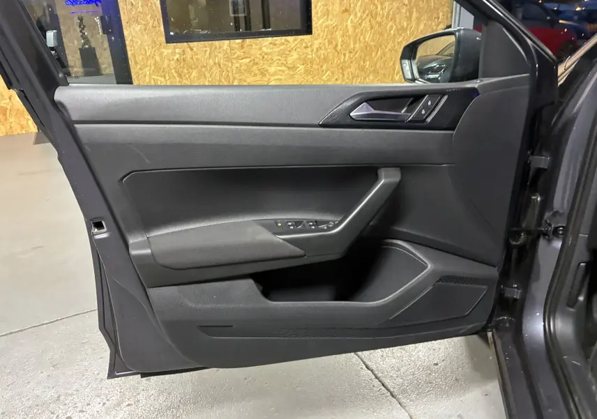 Vue rapprochée de la porte avant gauche gris foncé de la Volkswagen Polo VI 2025 avec commandes de vitres intégrées.