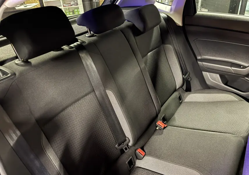 Vue intérieure des sièges arrière en tissu noir et gris de la Volkswagen Polo VI 2025, côté droit avec ceintures visibles.