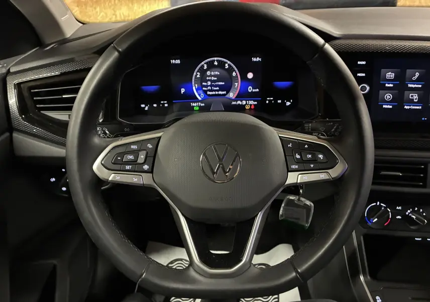 Vue rapprochée du volant noir de la Volkswagen Polo 2025 avec tableau de bord numérique et écran tactile central.