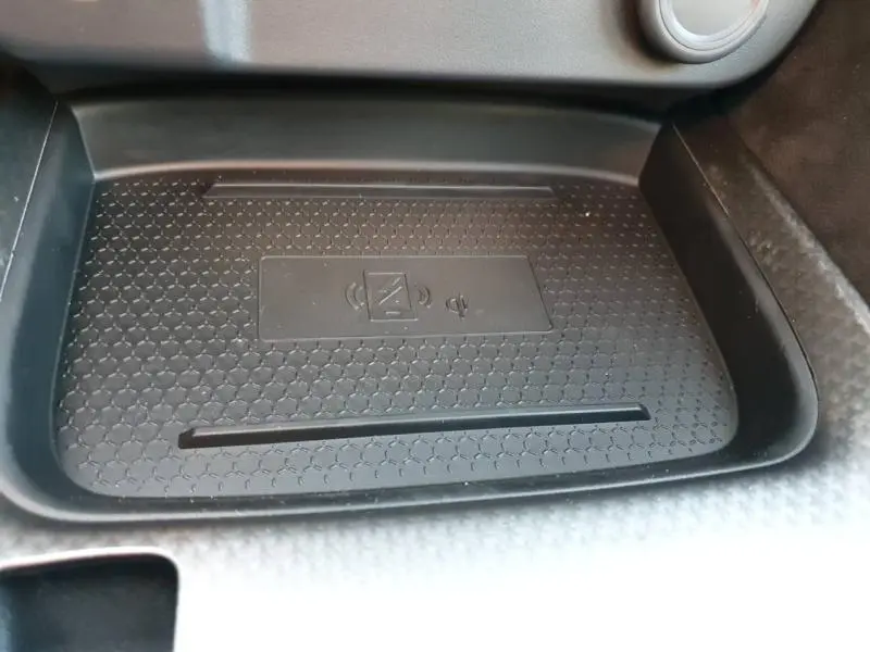Surface de recharge sans fil noire en gros plan dans l'habitacle du Nissan Qashqai Hybrid e-POWER 2025.