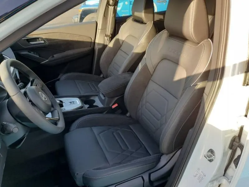 Vue intérieure côté conducteur du Nissan Qashqai Hybrid e-POWER 2025, sièges en tissu noir Bruneo chine avec surpiqûres contrastées.