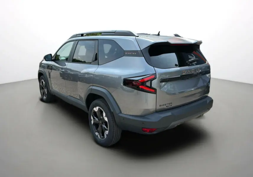 Vue 3/4 arrière gauche du Dacia Bigster gris schiste avec jantes alu 18 pouces et hayon électrique fermé.