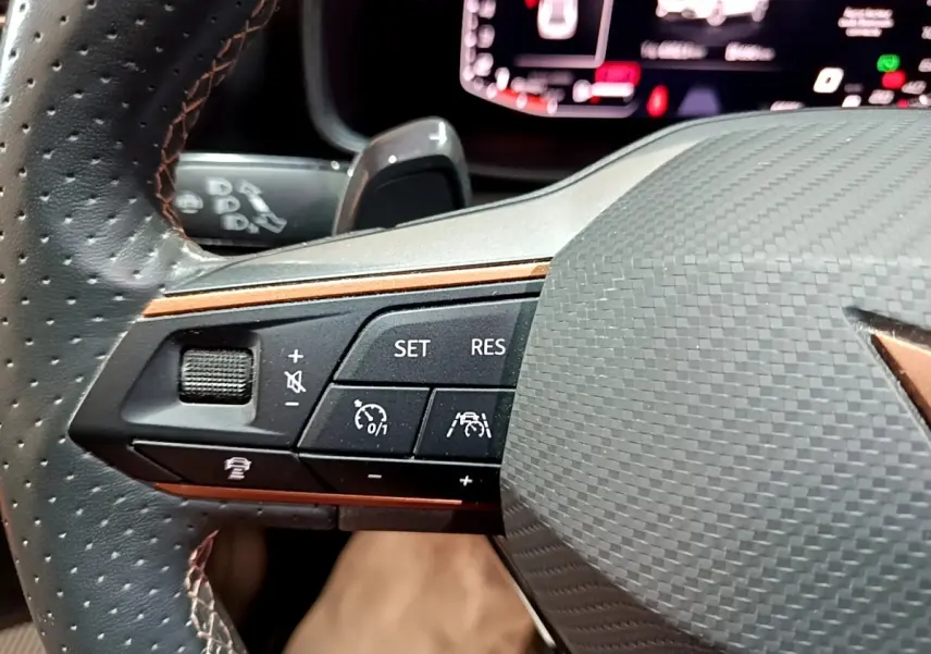 Gros plan sur le volant cuir et alu de la CUPRA Formentor gris foncé, avec commandes multifonctions et affichage digital.