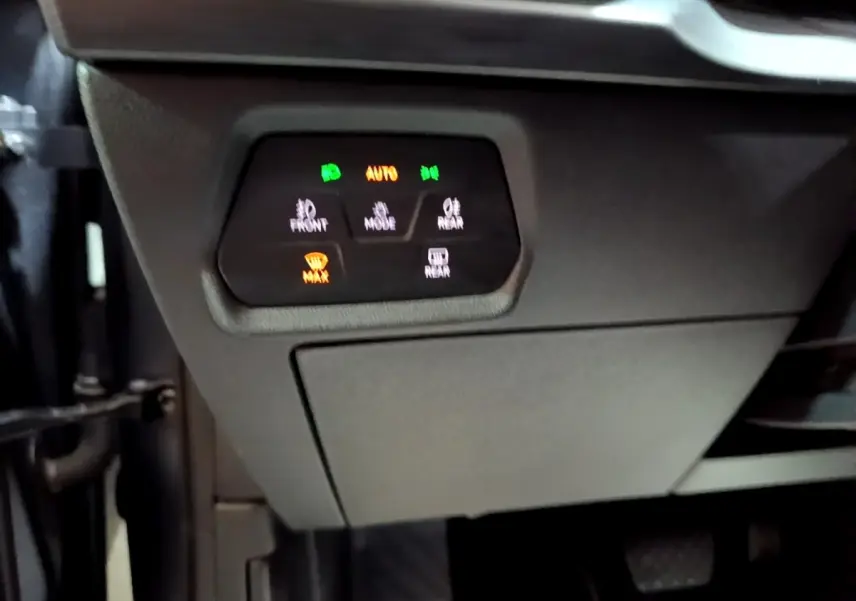 Gros plan sur les commandes d’éclairage et de désembuage sous le tableau de bord d’un CUPRA Formentor gris foncé.