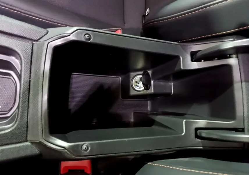 Vue plongeante sur le rangement central noir avec prise 12V du CUPRA Formentor gris foncé, intérieur cuir noir.