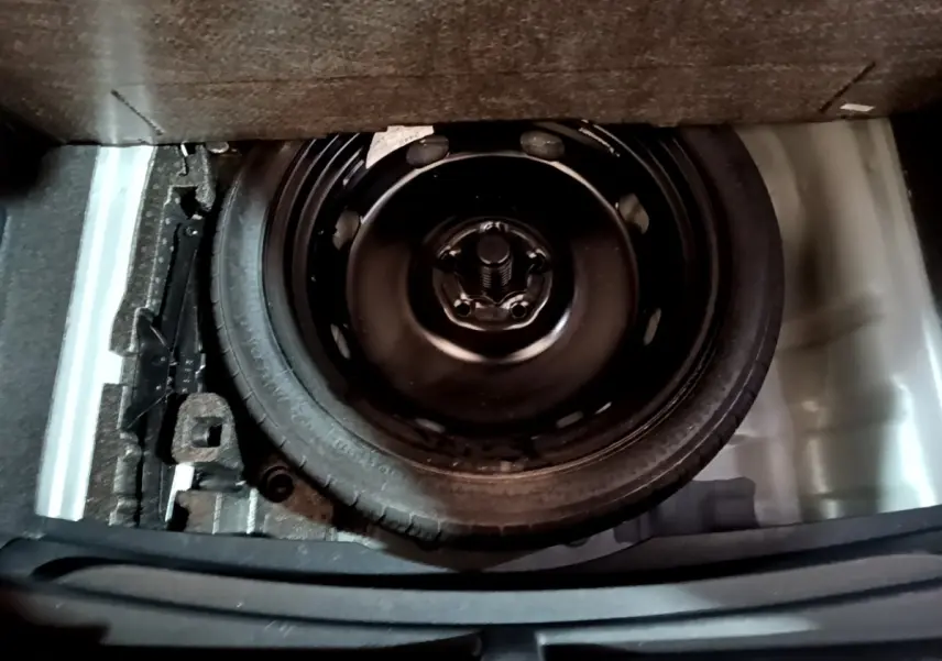 Vue plongeante sur la roue de secours noire dans le coffre du CUPRA Formentor gris foncé 2024.