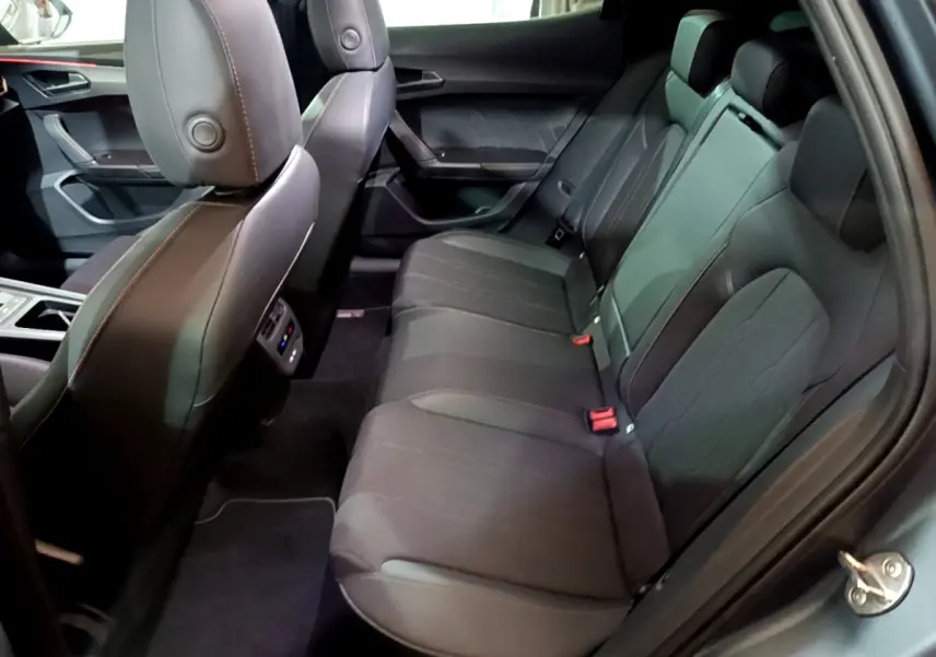 Vue latérale intérieure sur la banquette arrière noire du CUPRA Formentor 2024 avec finitions en cuir et tissu.