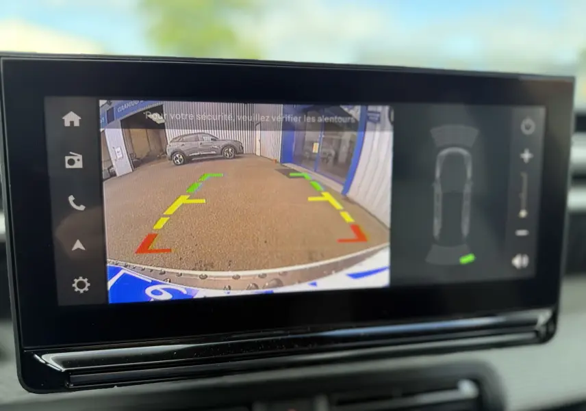 Écran multimédia montrant la caméra de recul du Citroën C3 Aircross blanc banquise avec toit noir, vue arrière en stationnement.