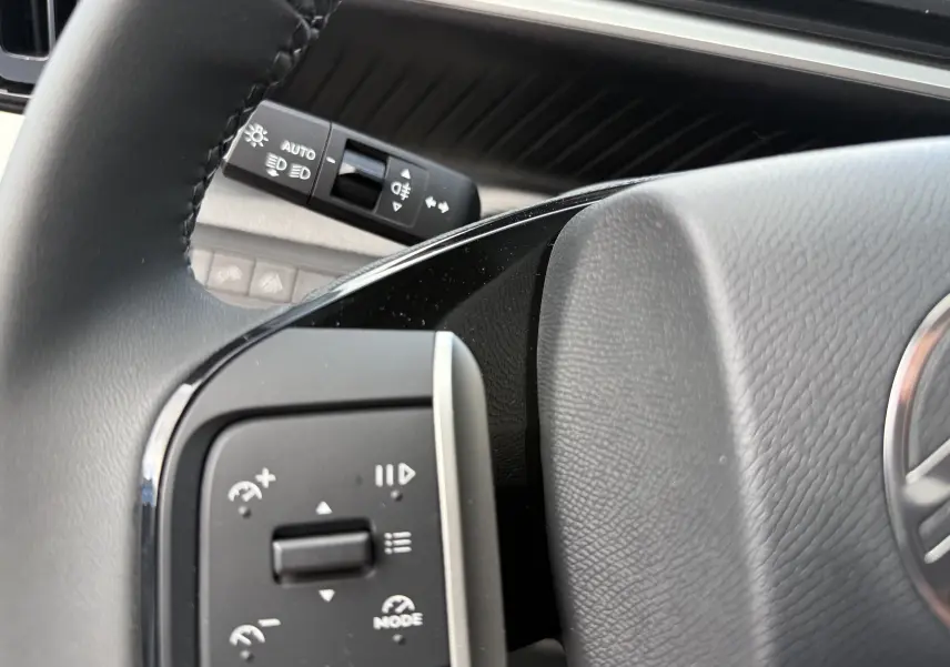 Gros plan sur les commandes au volant noir du Citroën C3 Aircross Hybrid 145, avec levier de clignotant en arrière-plan.