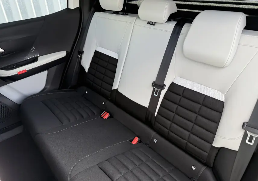 Vue intérieure du siège arrière bi-ton noir et blanc du Citroën C3 Aircross Hybrid 145, avec ceinture de sécurité centrale visible.