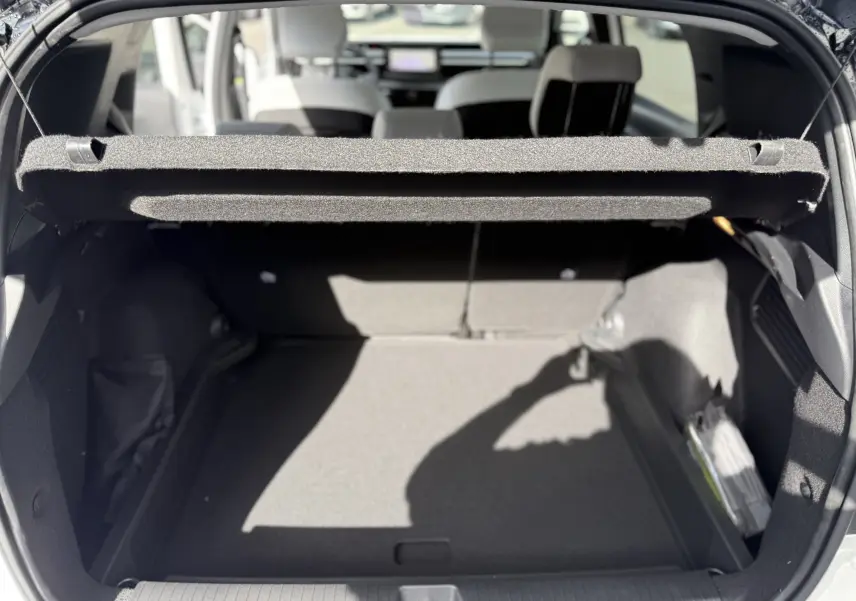 Vue arrière du coffre ouvert du Citroën C3 Aircross Hybrid 145 blanc banquise avec toit noir, montrant l'espace de chargement vide.