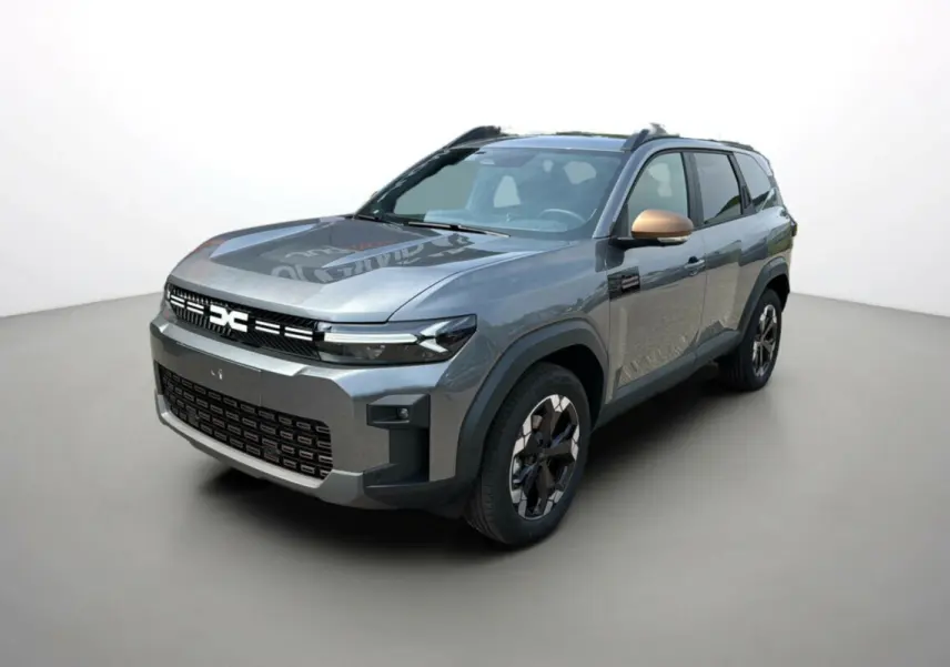 SUV Dacia Bigster Hybrid 155 Extreme Plus gris schiste vu en 3/4 avant avec rétroviseurs cuivrés et jantes alu noires.