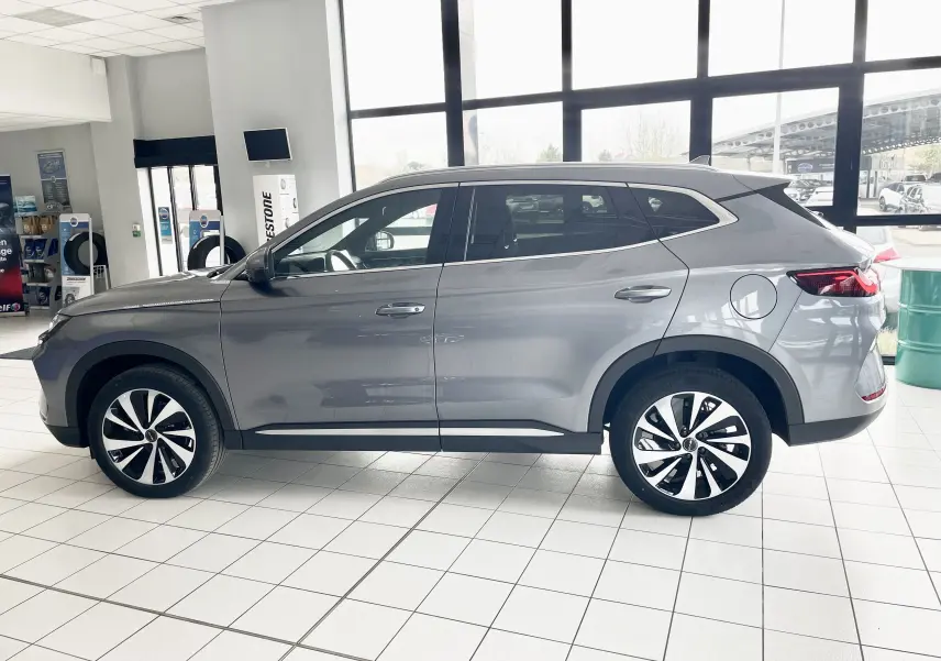 Vue de profil côté gauche du SUV BYD SEAL U hybride rechargeable en gris métallisé Time Grey dans un showroom.