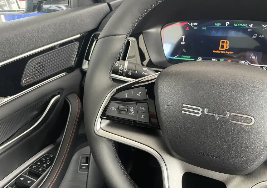 Vue intérieure frontale du tableau de bord du BYD SEAL U avec écran tactile 15,6'', volant multifonction et sièges marron.