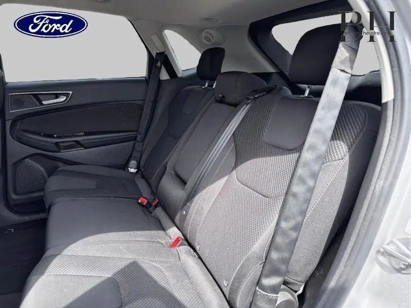 Vue intérieure côté gauche des sièges arrière en tissu noir du Ford Edge 2016 avec ceintures de sécurité visibles.
