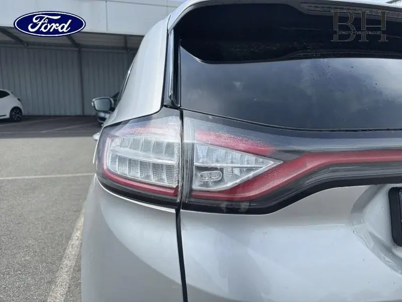 Gros plan sur le feu arrière gauche gris Ingot du Ford Edge 2016 avec hayon noir et attelage visible.