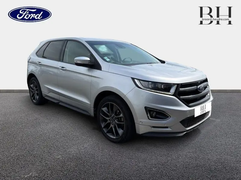 Vue 3/4 avant droit du Ford Edge gris Ingot avec jantes alliage foncé et calandre noire brillante.